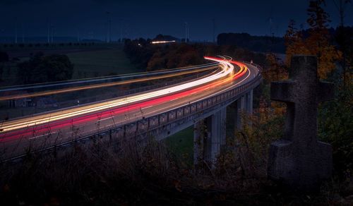 High angle view of light trails on bridge at night
