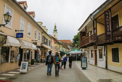 People walking on street amidst buildings in city