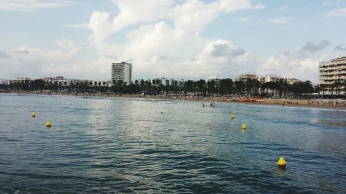 Scenic view of sea and cityscape against sky