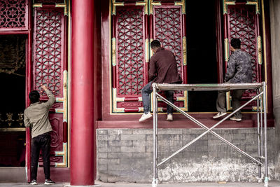 Rear view of people standing outside temple