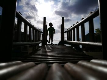Low angle view of people on railing