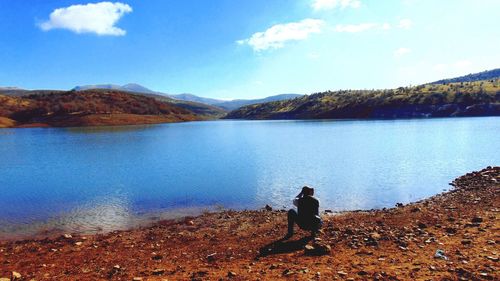 Rear view of a man overlooking calm lake