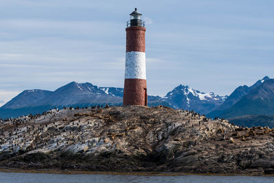 Lighthouse by sea against sky