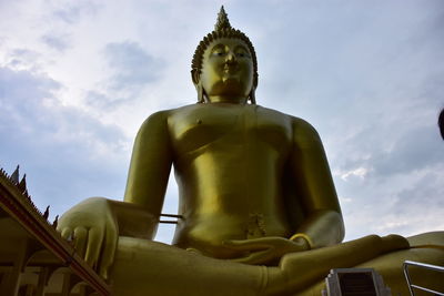 Low angle view of statue against temple building against sky