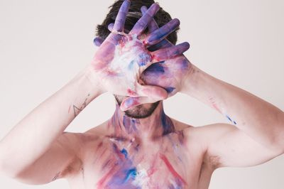 Close-up of human hand against colored background