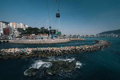 View of buildings by sea against sky