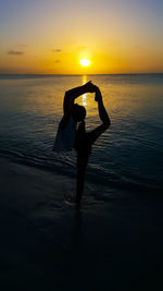 Silhouette of people on beach at sunset