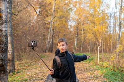 Full length portrait of man standing in forest