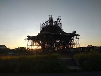 Low angle view of abandoned building against sky at sunset