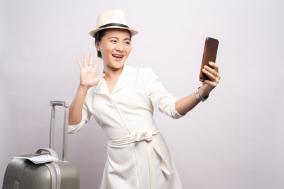 Young woman using mobile phone against white background