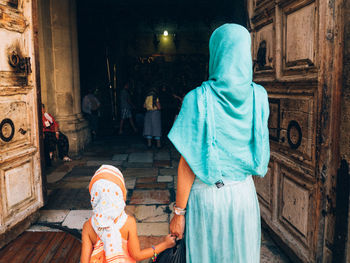 Rear view of mother with child entering church of holy sepulchre