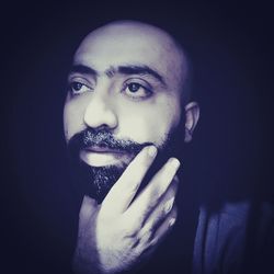 Portrait of young man against black background