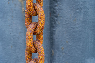 Close-up of rusty chain against wall