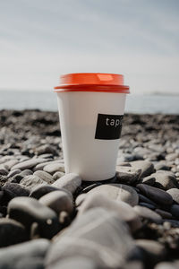 Close-up of coffee on a beach