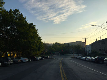 Cars on street in city against sky