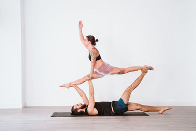 Full length of couple practicing acroyoga