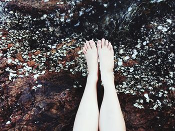 Low section of woman relaxing on rocks