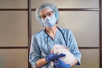 Portrait of veterinarian holding rabbit at hospital