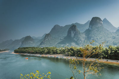 Scenic view of lake and mountains against clear sky