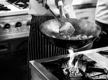 Person preparing food on barbecue grill