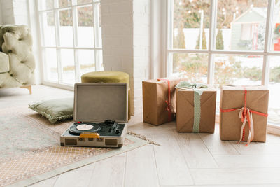 Vintage record player and christmas gifts near the window