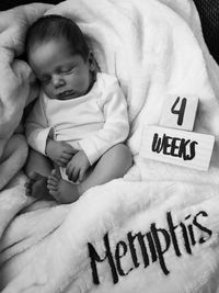 High angle view of baby lying on bed