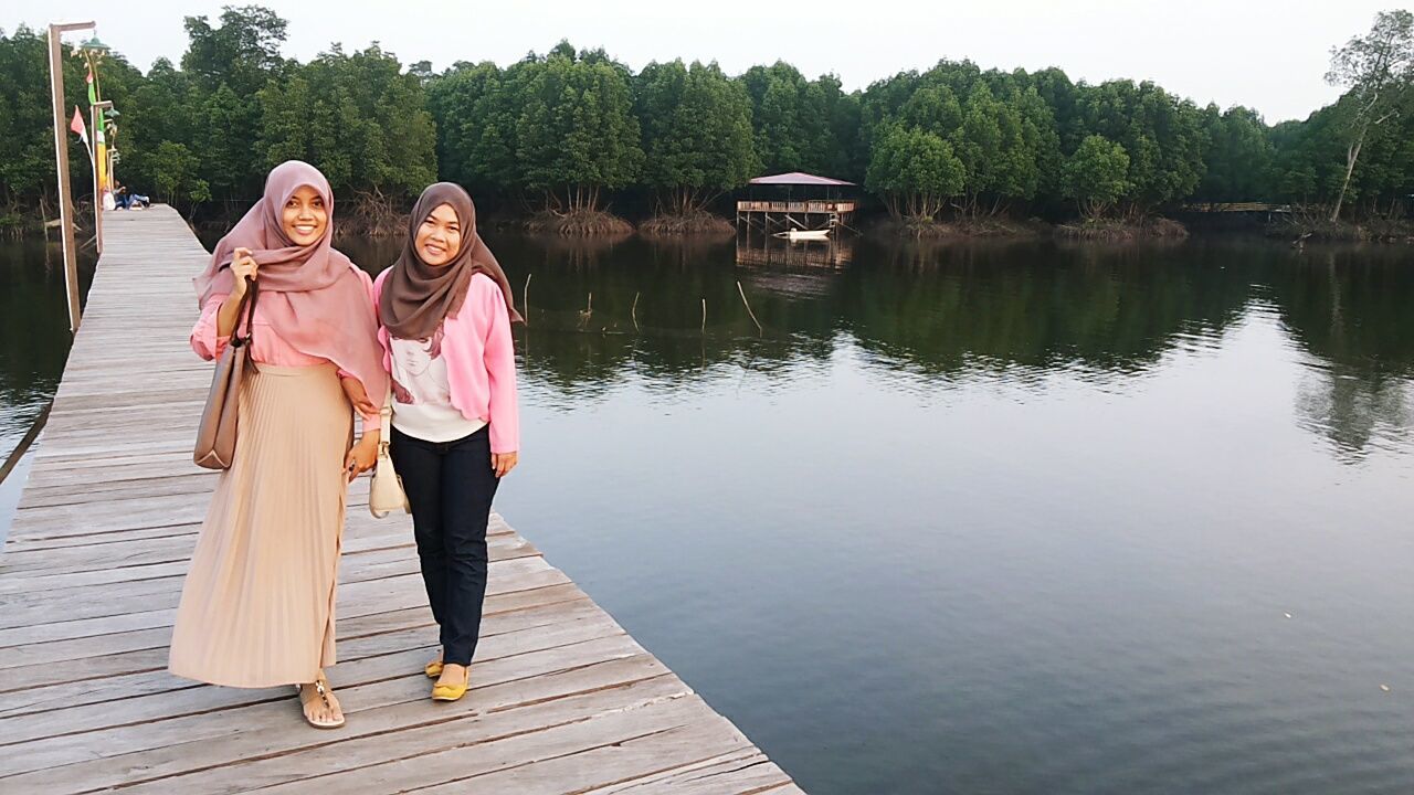 water, lifestyles, full length, casual clothing, leisure activity, lake, tree, standing, rear view, pier, wood - material, river, built structure, person, men, day, nature