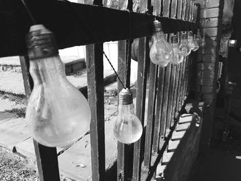 Close-up of light bulb hanging on wood