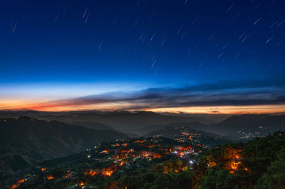 Scenic view of illuminated mountains against sky at night