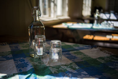 Close-up of glasses and bottle on table