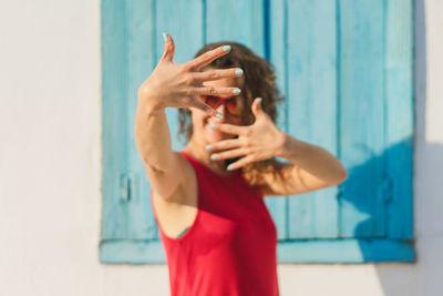 Midsection of woman standing against wall