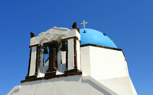 Low angle view of bell tower against clear blue sky