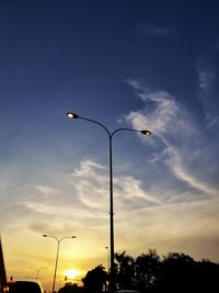 Low angle view of street lights against sky during sunset