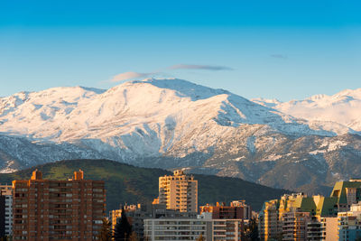 Skyline of residential apartment buildings with snowed los andes mountain range, santiago de chile