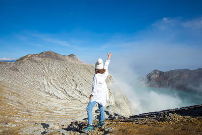 Man standing on mountain against sky