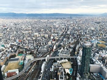 High angle view of crowd on road by buildings against sky