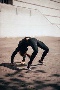 Full length of woman stretching outdoors