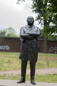 Man standing by statue against sky