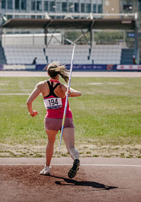 Full length of woman exercising on field