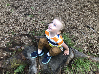 High angle view of boy sitting on land