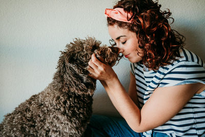 Woman with dog sitting at home