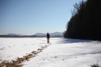 Man walking on snow covered landscape