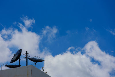 Low angle view of telephone pole against blue sky