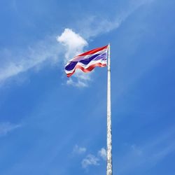 Low angle view of thai flag against blue sky