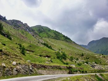 Scenic view of road amidst mountains against sky