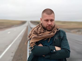 Portrait of young man standing on road