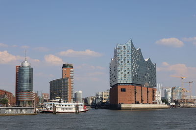 Sea by modern buildings against sky in hamburg 