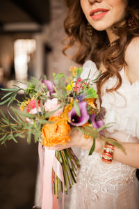 Midsection of woman holding flower bouquet