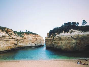 Rock formations on cliff by sea