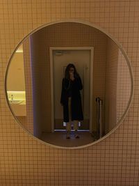Low angle view of woman standing against wall